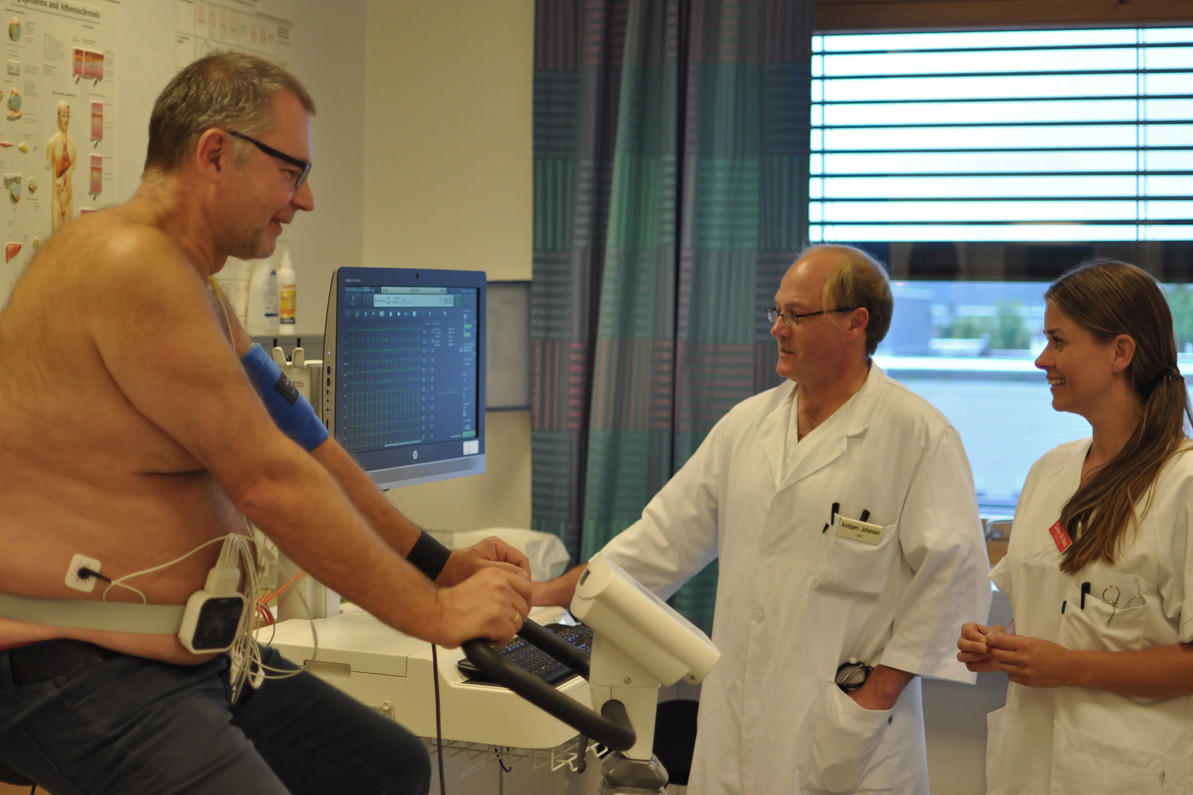 Pasient, lege og sykepleier på behandlingsrom i forbindelse med arbeids-ekg.