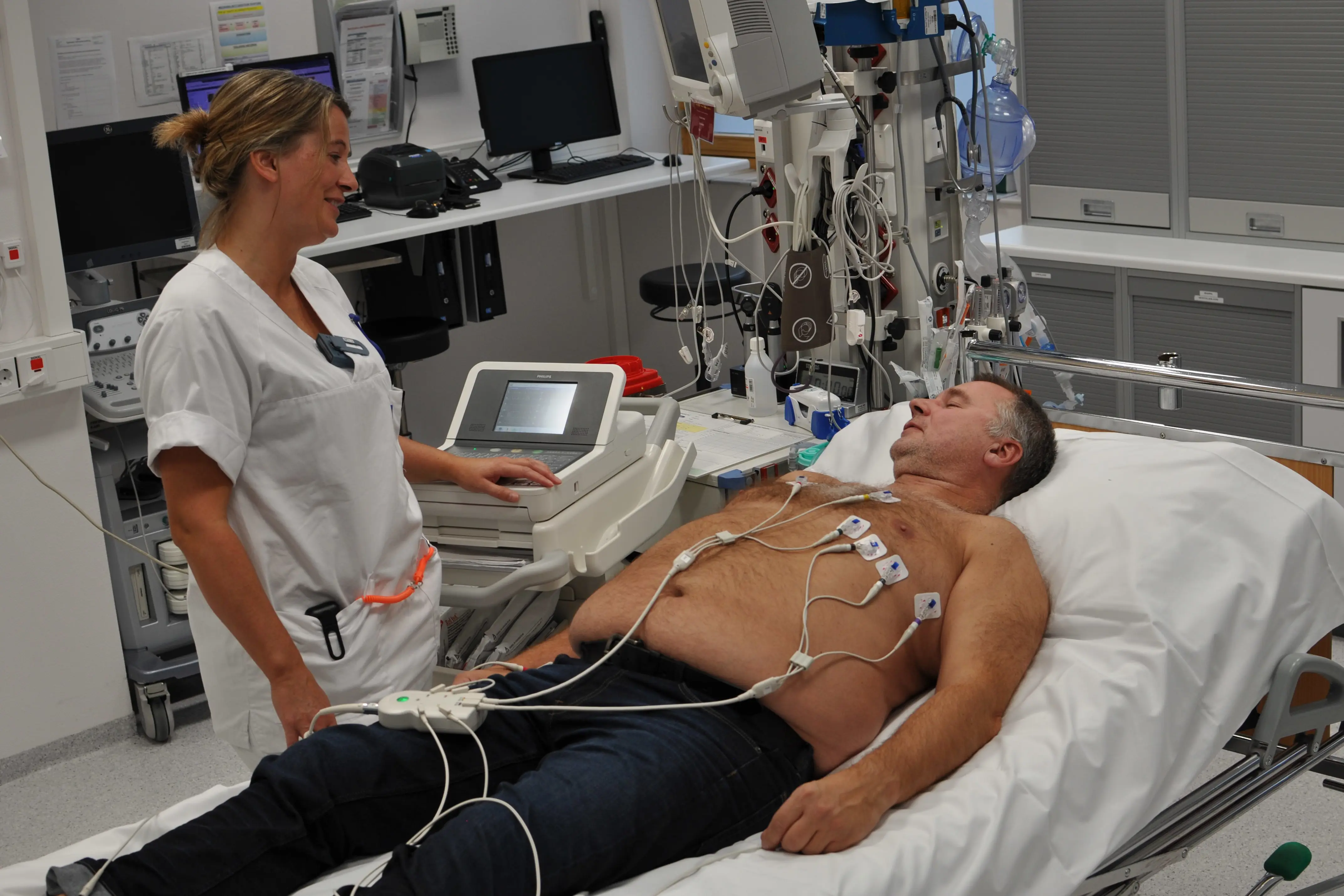 Sykepleier tar EKG av pasient. Foto.